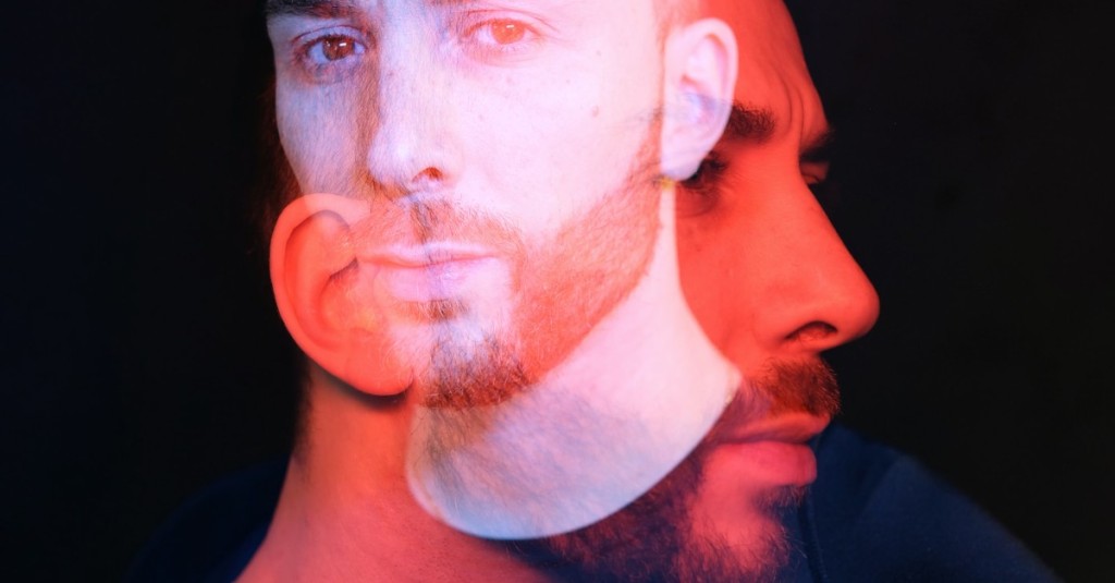 The abstract close up of a bearded man's face with a front and side profile overlapping