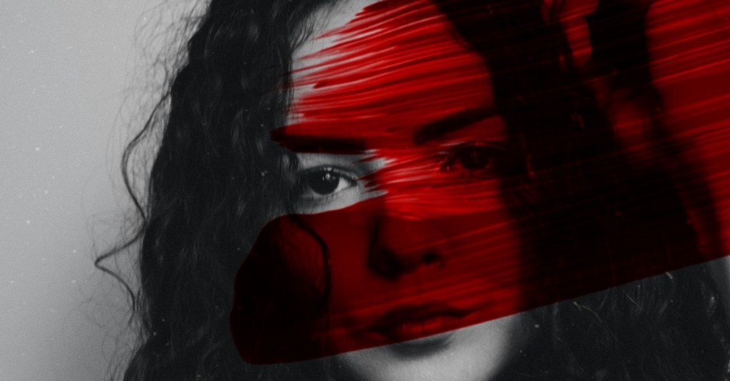 A black and white close up of a girl's face with a thick smear of blood covering it