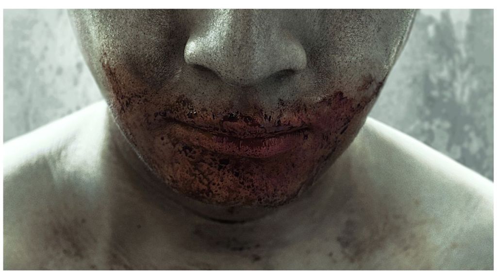 The close up of the lower half of a man's face with a bloodied mouth