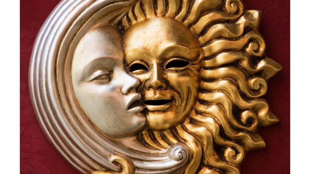 The metal sculpture of the moon and sun cheek to cheek